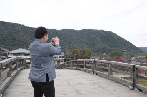 錦帯橋上で写真を撮る名越さん