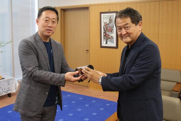 市長からカメラを手渡される光井さん