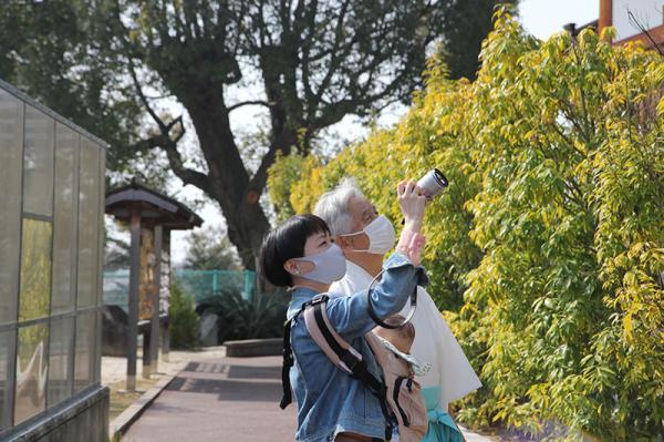 本殿を見上げる日高さんと平田宮司