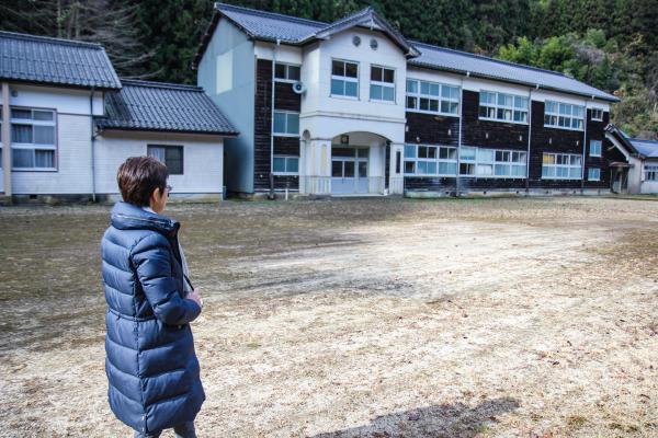 校庭を歩く三浦さんの写真