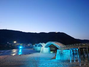 晴天の黄昏れとブルーのライトアップの錦帯橋