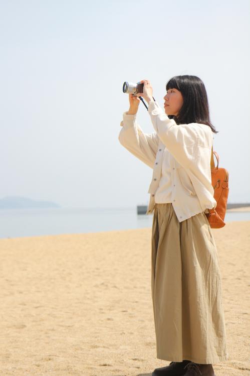 海岸で撮影するすずきえりなさん