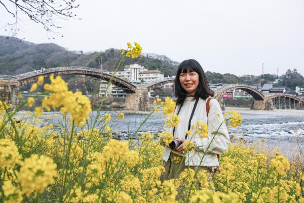 菜の花に囲まれるすずきえりなさんの写真