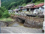 集落と清流線の下を山の水が流れている光景です。