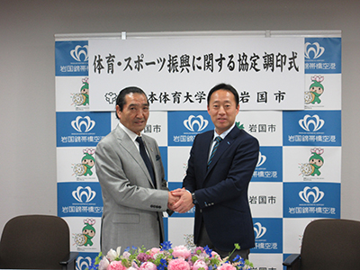 調印式で握手を交わす福田市長と松浪理事長
