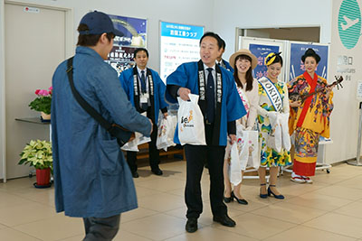 沖縄からの第1便で到着したお客様を出迎える福田市長