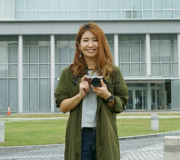 カメラを手に笑顔の原田さん