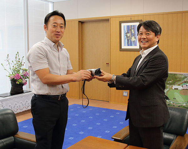 福田市長からカメラを受け取る中馬浩さん