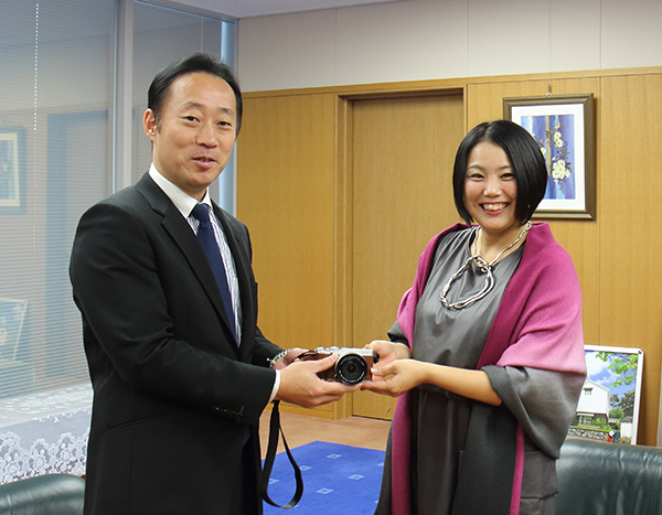 福田市長からカメラを受け取るMIKAKOさん