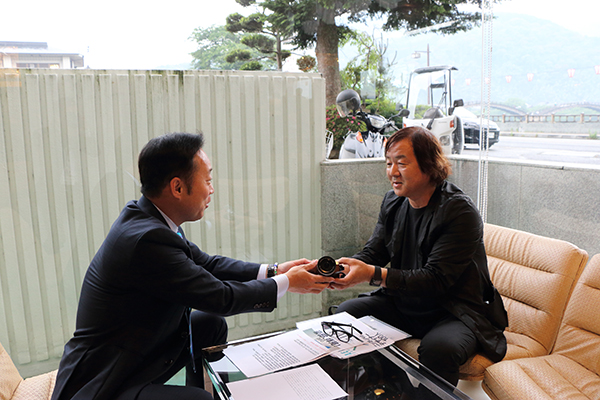 福田市長からカメラを受け取る小川晋一さん